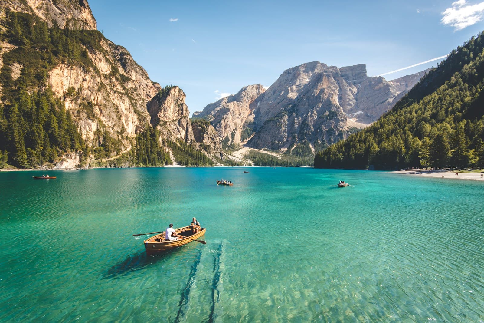 Italy: three brown wooden boat on blue lake water taken at daytime