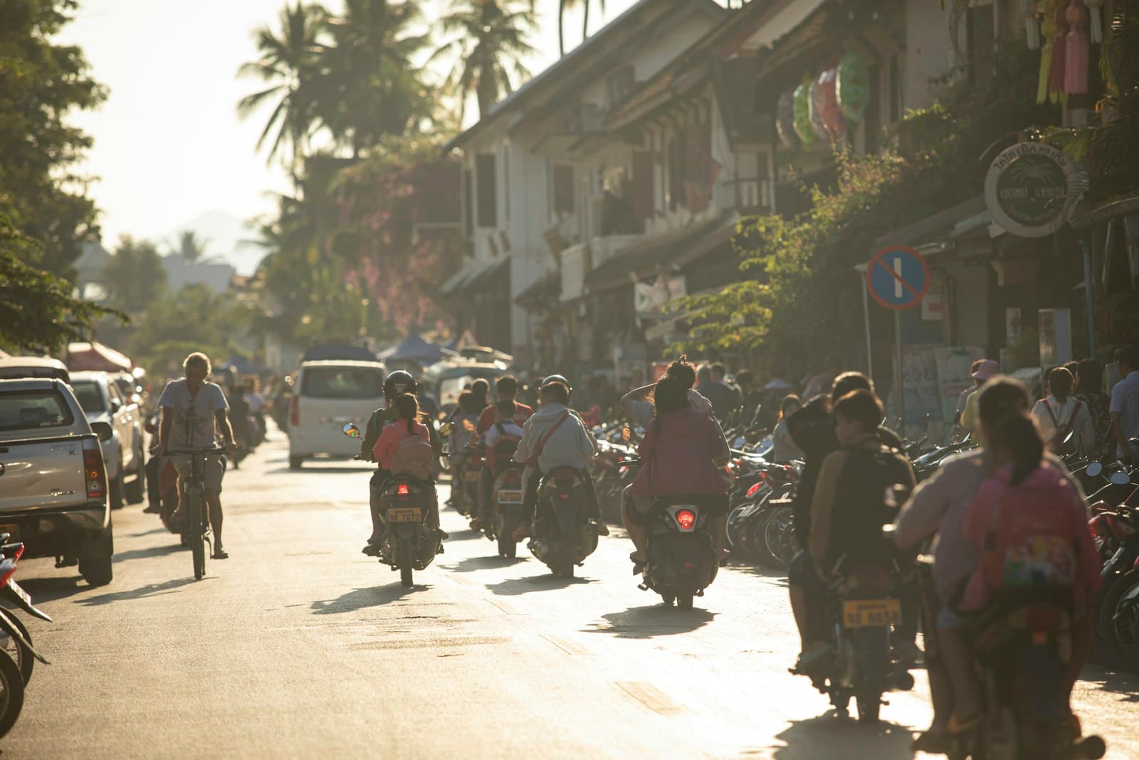 Southeast Asia: A group of people riding motorcycles down a street