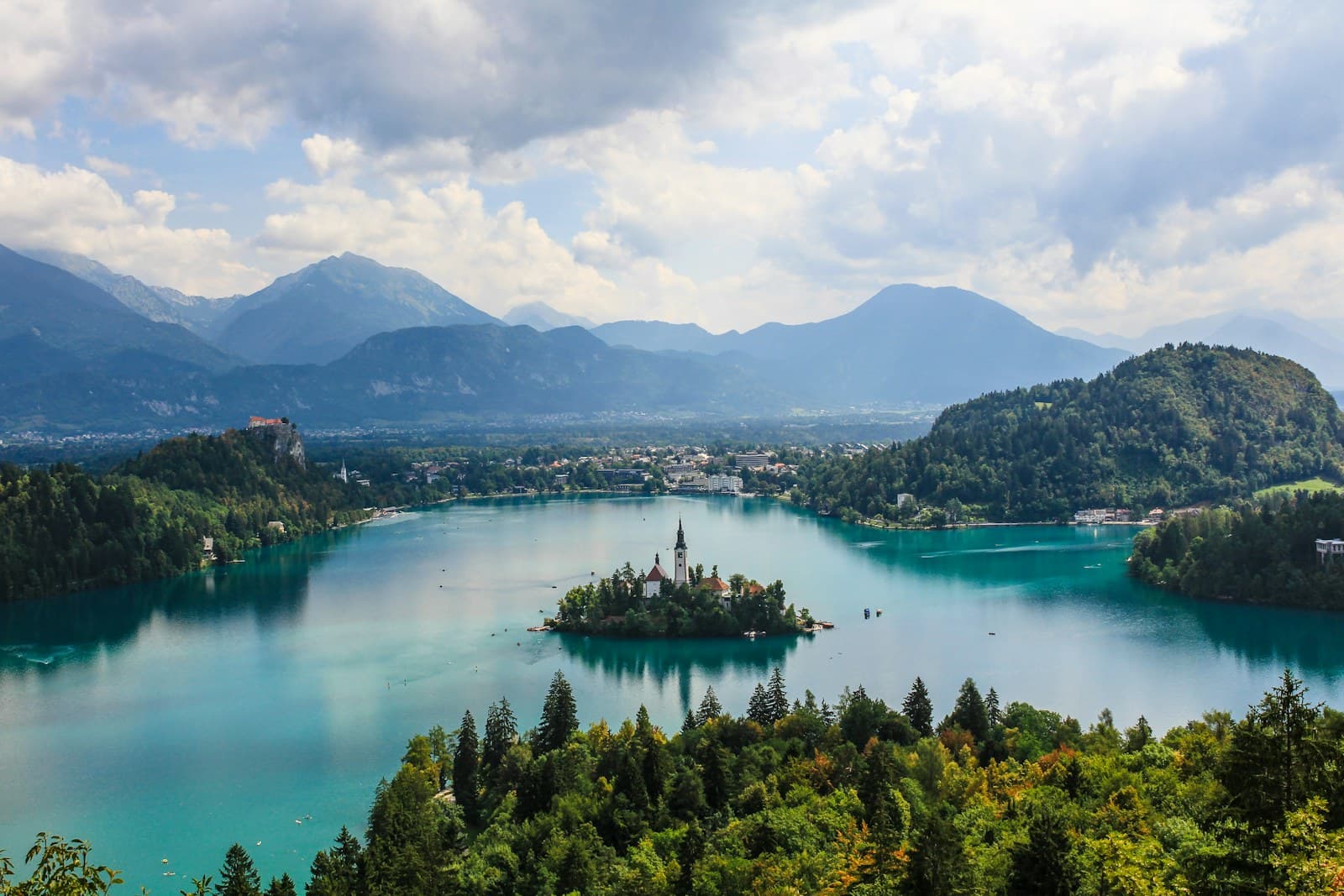 Slovenia: high-angle photography of white building surrounded by body of water at daytime
